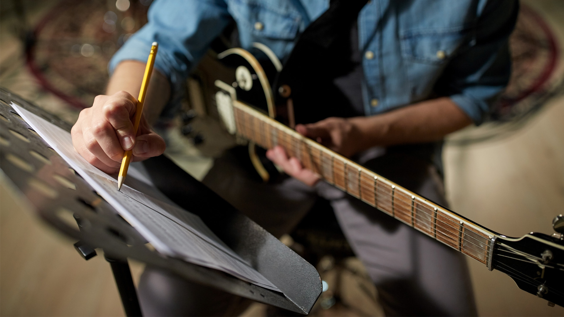 Créateur avec guitare écrivant sur une partition